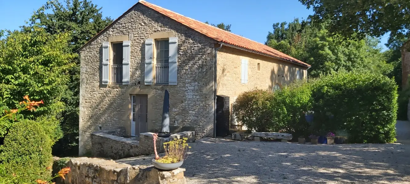 Cours d'entrée en gravier devant la maison en pierres